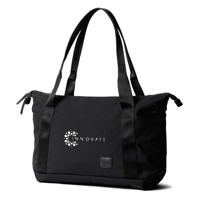A black tote bag with dual handles, featuring a logo on the front and a zippered closure.