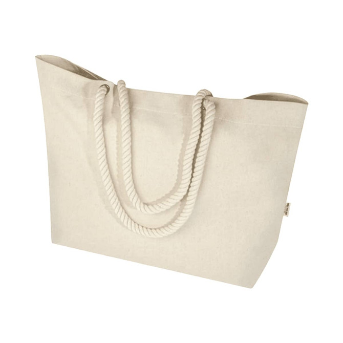 A large beige tote bag with rope handles and a simple design. Features a logo on one side.