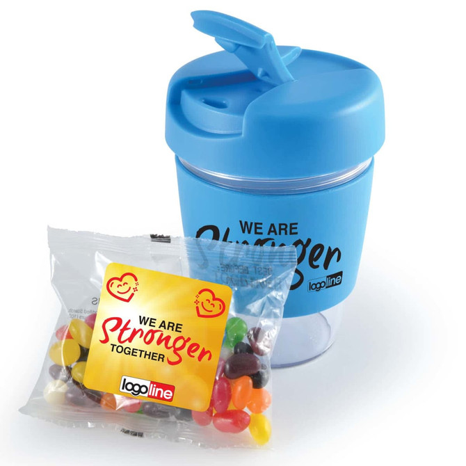 A reusable coffee cup in light blue with a lid, accompanied by a bag of colorful jelly beans. The cup features a logo.