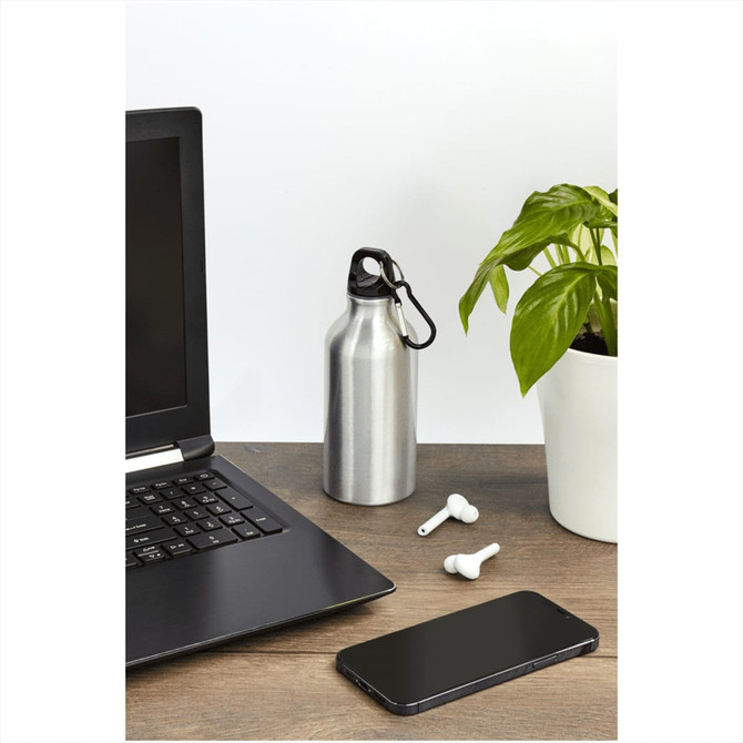 A drink bottle in silver stainless steel with a carabiner, placed near a laptop and smartphone on a desk.