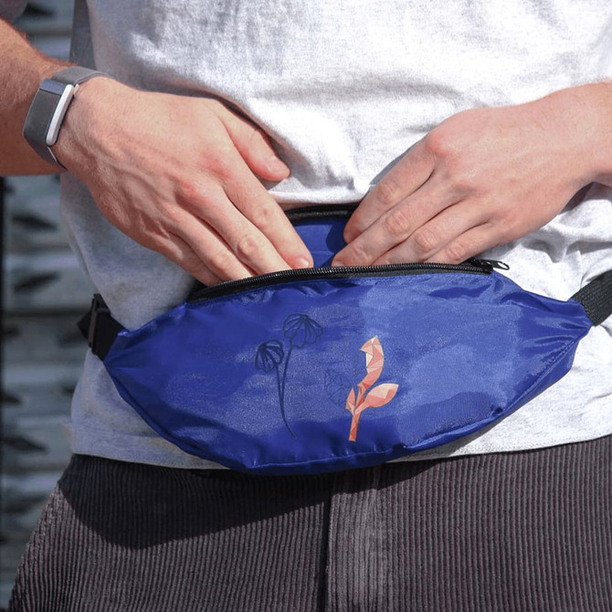 A blue bum bag featuring a floral design, being worn by a person with hands adjusting it.