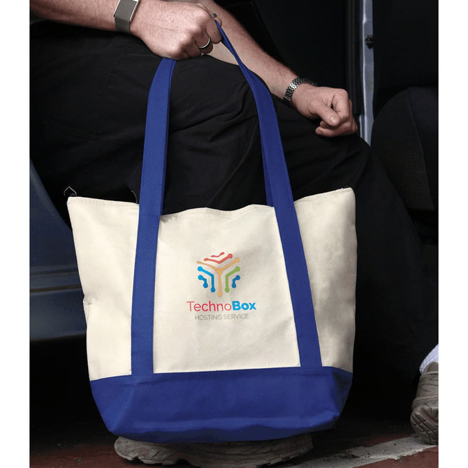 A non-woven tote cooler with a cream body and blue base, featuring a logo on the front.
