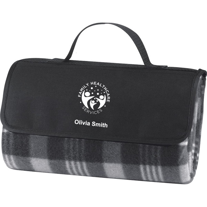 A picnic rug in black and grey, featuring a carrying handle and a logo on the front.