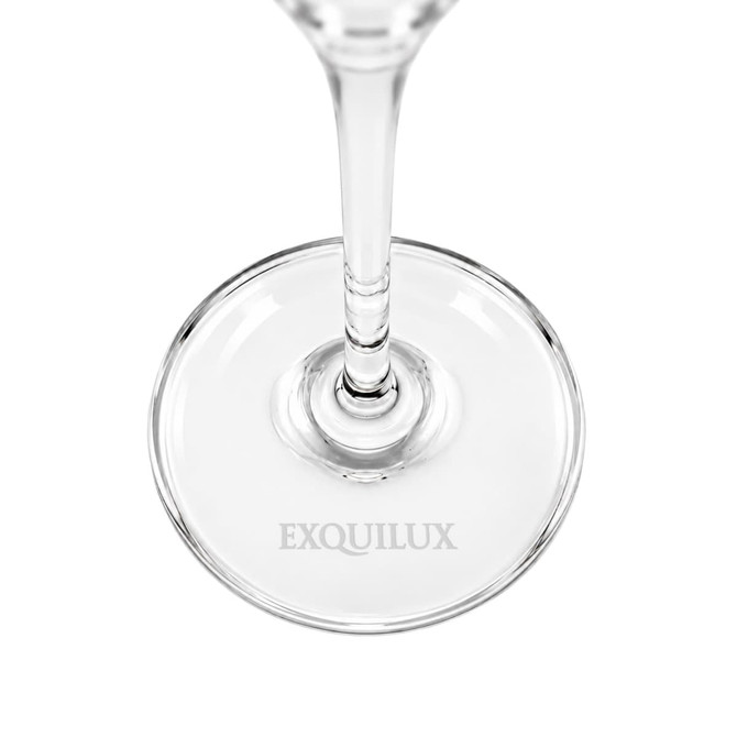 A clear glass flute with a slender stem and a round base, featuring a logo on the base.