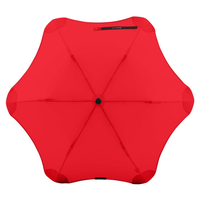A red BLUNT Metro Umbrella with a unique design and a central button, featuring a logo on it.