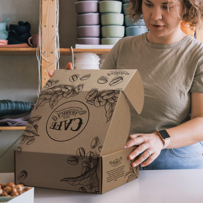 A woman is assembling a brown die cut box with a locking lid, featuring coffee bean illustrations and a logo.