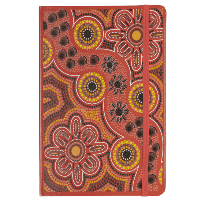 A vibrant red journal with Indigenous-inspired floral and dot designs, featuring an elastic band closure.