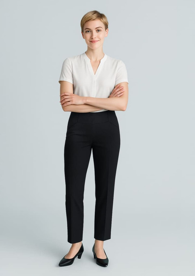 A model wearing women's black slim leg pants and a white short-sleeved top, standing with arms crossed.