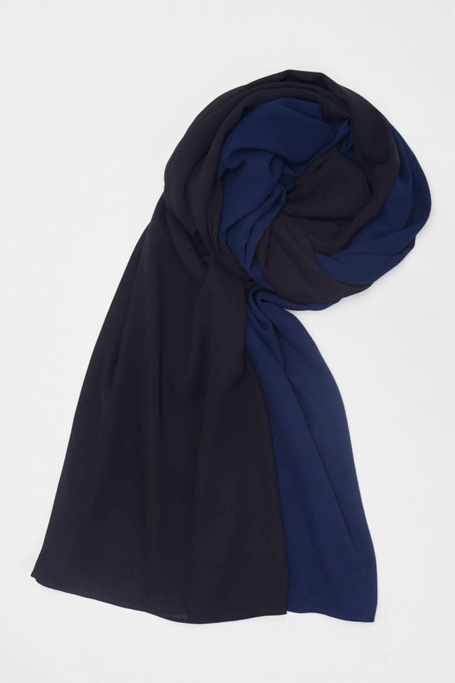 A women's hijab featuring a blend of black and navy blue fabric, elegantly draped. A women's hijab featuring a blend of black and navy blue fabric, elegantly draped.