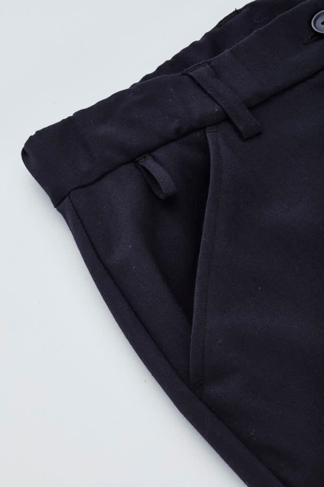 A close-up of navy women's cargo pants featuring a comfort waist and side pockets, with a logo on the fabric.