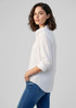 A white women's long sleeve button-up shirt, featuring a relaxed fit and rolled sleeves. It has a subtle logo.