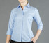 A light blue button-up shirt with a fitted design and three-quarter length sleeves. It features a collar and branding.