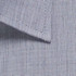 A close-up of a textured, light blue button-up shirt fabric with a collar. The fabric features a subtle pattern and has a logo.