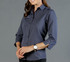 A dark navy button-up shirt with long sleeves, featuring a fitted design. The model is wearing a watch.