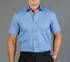 A short-sleeved, button-up shirt in a light blue colour with a single chest pocket. The model is wearing black trousers.