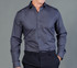 A button-up shirt in dark grey with long sleeves and a fitted design, featuring a logo on the chest.