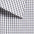 A close-up of a button-up shirt featuring a grey and white gingham pattern with a folded collar.