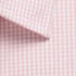 A close-up of a button-up shirt featuring a pink and white gingham pattern with a collar.