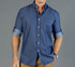 A button-up shirt in navy chambray with rolled-up sleeves and a subtle pattern, featuring a logo.