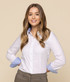 A woman models a button-up shirt featuring a white body and light blue cuffs and collar. The shirt has a logo present.