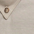 A close-up of a beige work shirt collar featuring a button and textured fabric. It has a logo on the shirt.