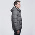 A grey puffer jacket with a hood, featuring a zip closure and side pockets, worn by a man in profile.