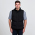A black puffa vest is worn over a grey short-sleeve shirt, featuring a high collar and side zip pockets.