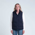 A woman wearing a navy puffa vest with a zip and button closure, featuring side pockets.