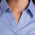 A blue button-up shirt with a collar and a textured fabric, featuring a logo on the chest area.
