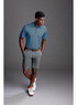 A pair of grey sports shorts, styled with a blue polo shirt and white sneakers, featuring a logo on the shorts.