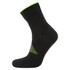 A black trainer sock with green accents, featuring a textured design and a branded logo.