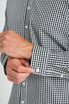 A close-up of a black and white checked long sleeve button-up shirt with white buttons.