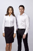 A long sleeve white button-up shirt displayed on a male and female model, both wearing professional attire.