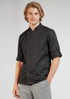 A black long sleeve chef jacket with rolled-up sleeves, modelled by a young man. It features a logo on one sleeve.