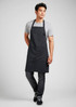 A black apron worn by a man, featuring a simple design and a front pocket, with a logo visible.