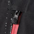 A close-up of a black softshell jacket featuring a zip closure and a red interior. The jacket includes a logo detail.