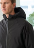 A man wearing a black unisex rain jacket with a hood, showcasing a sleek design and branding.