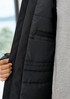 A unisex black rain jacket with a quilted interior and a visible pocket inside. The fabric looks smooth and durable.