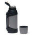 A drink bottle in grey with a black, textured grip and a matching cup beside it. The bottle has a lid with a spout and a logo.