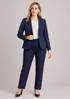 A navy mid-length jacket paired with matching tailored trousers, featuring a white blouse and black heels.