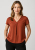 A rust-coloured women's V-neck blouse with short sleeves and pleat detail, featuring a logo on the tag.
