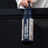A drink bottle in navy blue with intricate patterns and a logo, designed for holding 750ml of liquid.