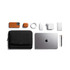 A black laptop caddy with a silver laptop, accessories in orange and white including a phone, mouse, and charger.