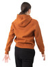 A woman wearing a rust-coloured hoodie with a kangaroo pocket, viewed from the back. The hoodie has a logo.