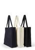 A set of three heavy tote bags in black, cream, and navy, each featuring sturdy handles and a logo.