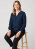 A navy women's long sleeve blouse with a relaxed fit, featuring a V-neck and balloon sleeves, displayed on a stool. A navy women's long sleeve blouse with a relaxed fit, featuring a V-neck and balloon sleeves, displayed on a stool.