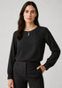 A black long sleeve blouse with a keyhole neckline, paired with tailored trousers. It has a simple, elegant design. A black long sleeve blouse with a keyhole neckline, paired with tailored trousers. It has a simple, elegant design.