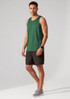 A man models a green singlet with black shorts, featuring a logo on the singlet.