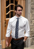 A slim fit white button-up shirt on a man, paired with a striped tie and black trousers, featuring a logo on the shirt.