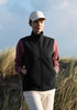 A unisex vest in black, worn over a pink long-sleeve top, complemented by a beige cap. Features a logo.